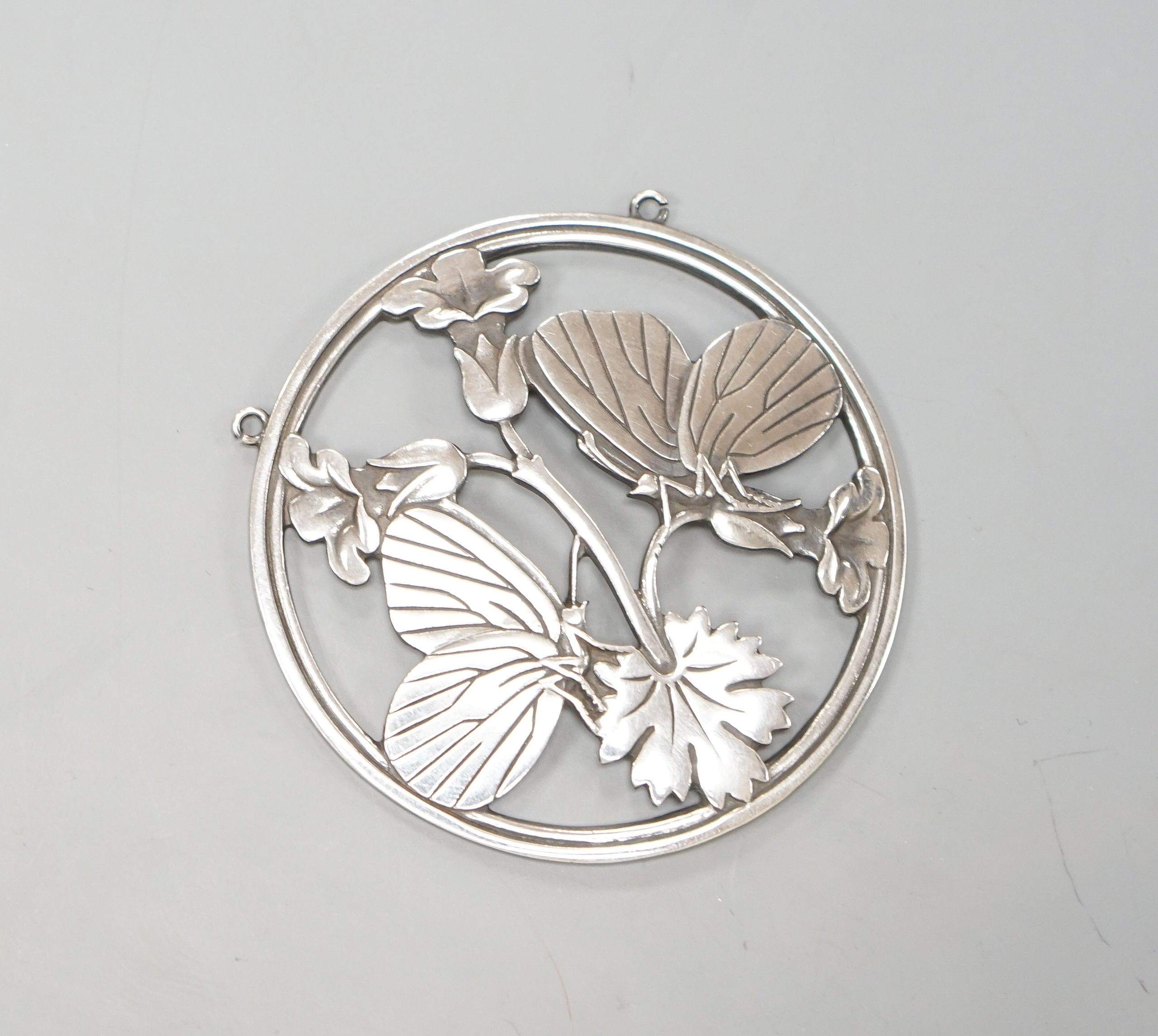 A Georg Jensen sterling circular 'two butterflies on flower' pendant, designed by Arno Malinowski, no. 105, 52mm.